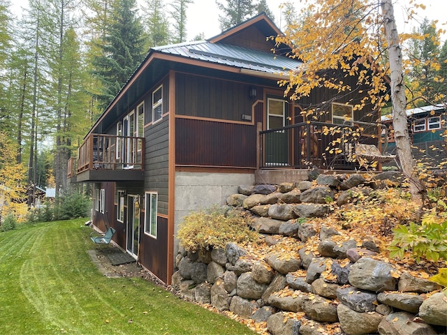 view of side of home with metal roof and a yard