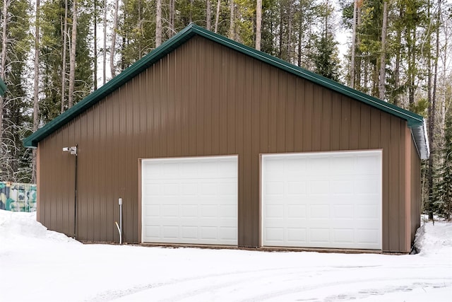 snow covered garage featuring a detached garage