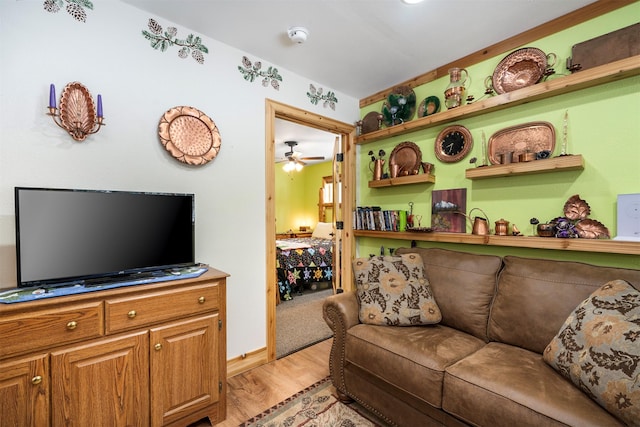 living area featuring light wood-style flooring and ceiling fan