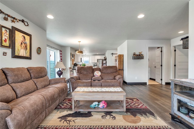 living room with dark wood-style floors, recessed lighting, a textured ceiling, and baseboards