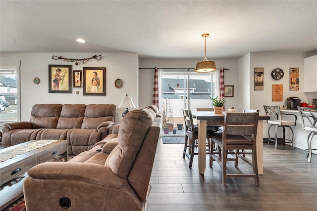 dining space with plenty of natural light, dark wood-style floors, and a textured ceiling