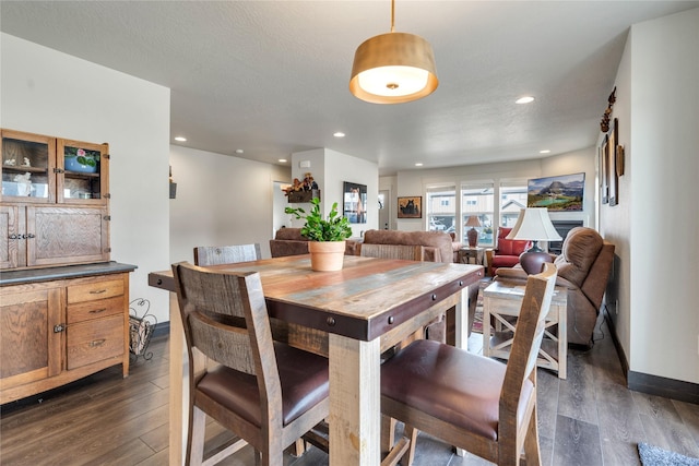 dining area with dark wood-type flooring, recessed lighting, baseboards, and a textured ceiling