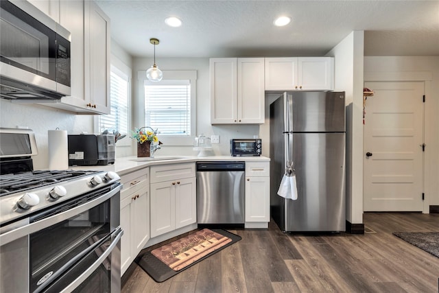 kitchen with recessed lighting, white cabinetry, stainless steel appliances, and dark wood-style flooring