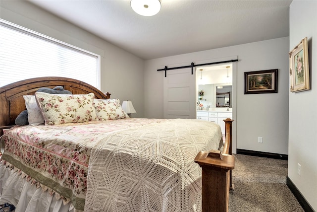 carpeted bedroom featuring connected bathroom, baseboards, and a barn door