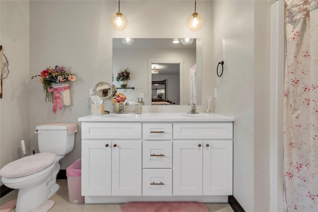 bathroom featuring a sink, toilet, and double vanity