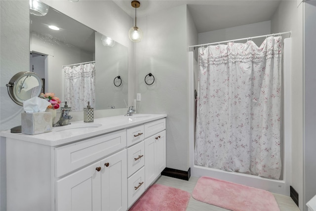 bathroom featuring a sink, a shower with curtain, and double vanity