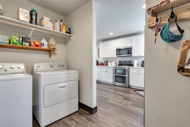 laundry area with washing machine and dryer, recessed lighting, light wood-style floors, baseboards, and laundry area