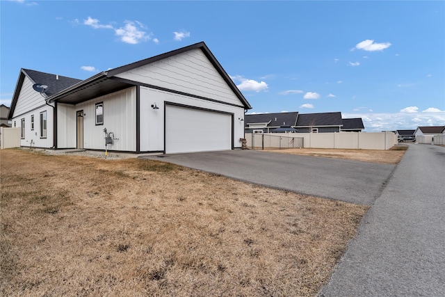 exterior space with concrete driveway, fence, and a garage