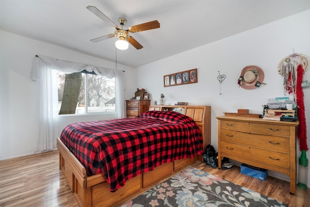 bedroom featuring a ceiling fan, light wood-style floors, and vaulted ceiling