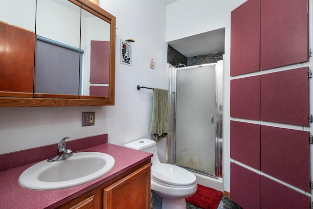 full bath featuring toilet, a stall shower, and vanity