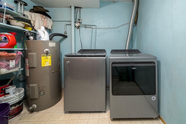 laundry room with laundry area, washing machine and dryer, and water heater