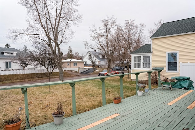 wooden terrace with fence, a lawn, and a residential view