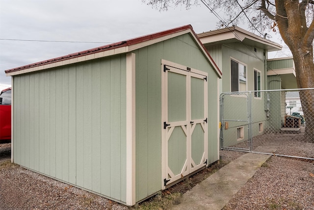 view of shed featuring fence and a gate