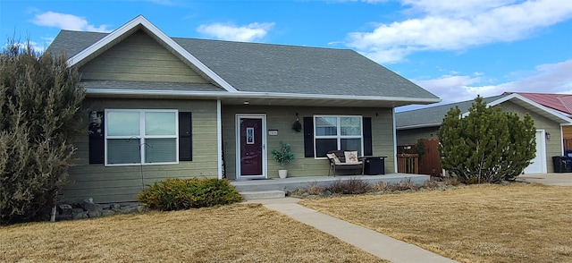 bungalow-style house with covered porch, a front lawn, and a shingled roof