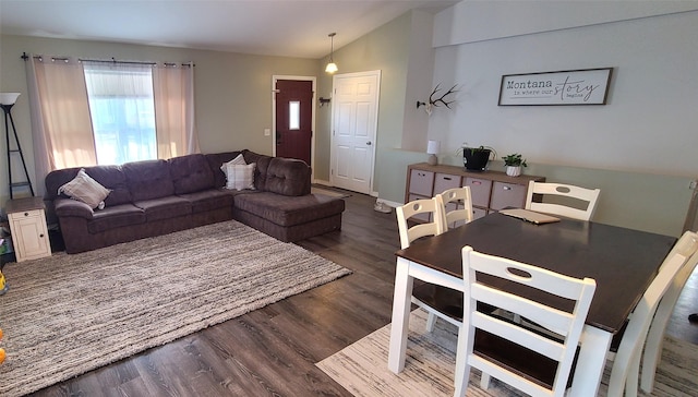 living area featuring baseboards, wood finished floors, and vaulted ceiling