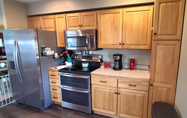 kitchen featuring light brown cabinetry, stainless steel appliances, and light countertops