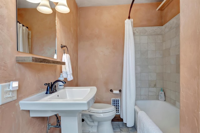 bathroom with toilet and shower / tub combo with curtain