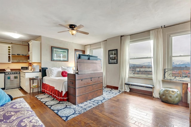 bedroom with ceiling fan, baseboards, and hardwood / wood-style floors