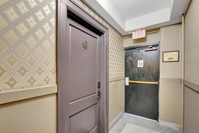 interior space featuring wallpapered walls and granite finish floor