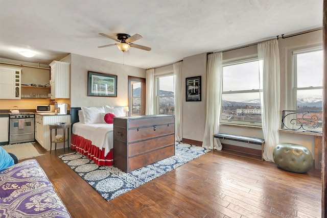 bedroom featuring ceiling fan, baseboards, and wood-type flooring