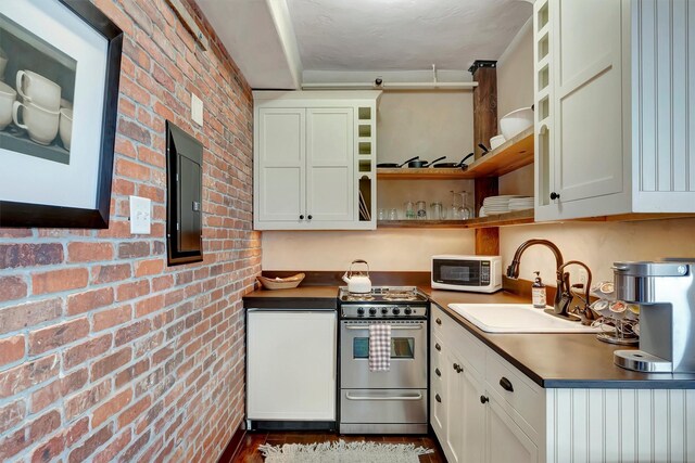 131 S Higgins Ave Unit 7-2, Missoula, MT 59802 - kitchen with stainless steel range, open shelves, white microwave, brick wall, and dark countertops