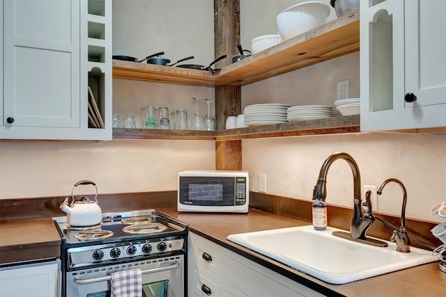 kitchen with a sink, open shelves, stainless steel electric stove, and white cabinetry