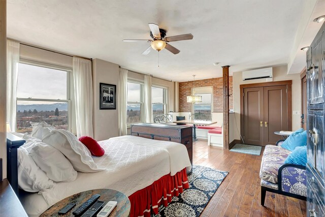 131 S Higgins Ave Unit 7-2, Missoula, MT 59802 - bedroom with an AC wall unit, light wood-type flooring, multiple windows, and a ceiling fan