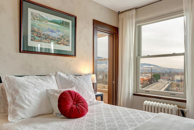 bedroom featuring radiator heating unit and wallpapered walls