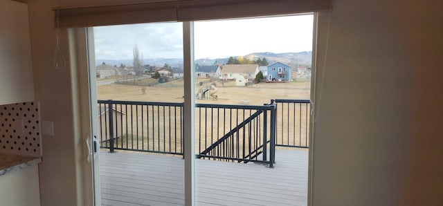 doorway with a wealth of natural light, a residential view, and a mountain view