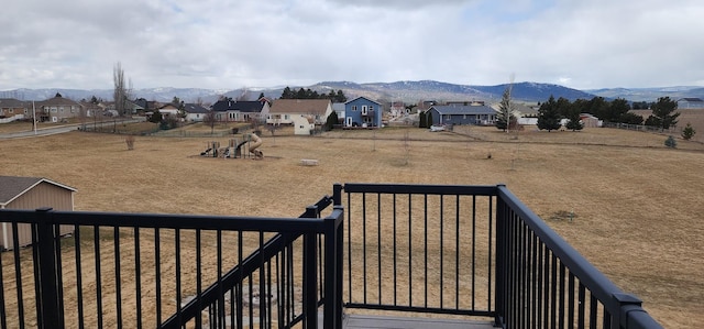 exterior space featuring a residential view, a mountain view, and fence