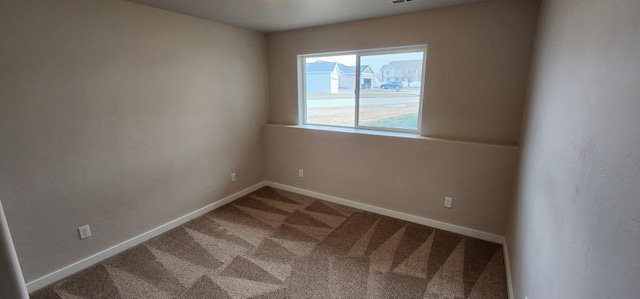 carpeted spare room with baseboards