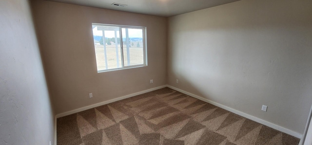 carpeted empty room featuring visible vents and baseboards