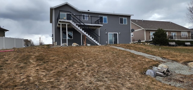 back of house with stairway, a deck, and fence