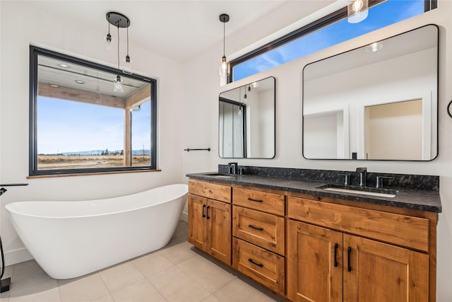 bathroom featuring a sink, a freestanding tub, double vanity, and tile patterned flooring