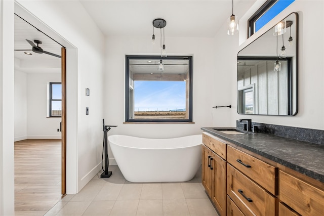 bathroom featuring vanity, a soaking tub, baseboards, and tile patterned floors