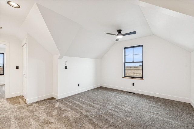 additional living space featuring visible vents, carpet floors, baseboards, and vaulted ceiling