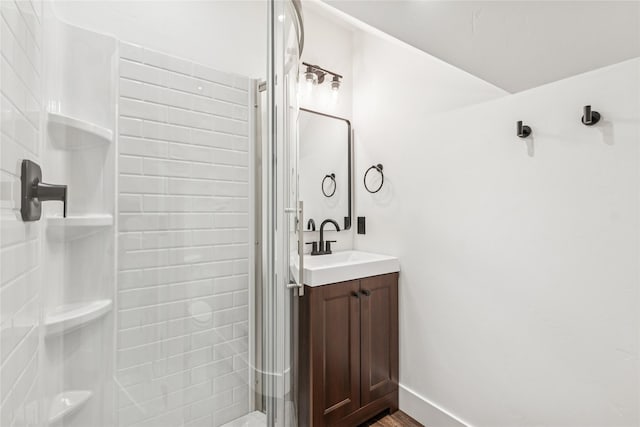 full bath featuring a shower, baseboards, wood finished floors, and vanity