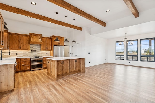 kitchen with custom range hood, a sink, a center island, an inviting chandelier, and appliances with stainless steel finishes