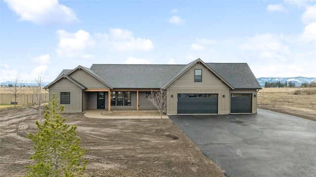 view of front of home featuring aphalt driveway and a shingled roof