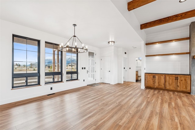 unfurnished living room featuring baseboards, visible vents, beam ceiling, light wood-type flooring, and a chandelier