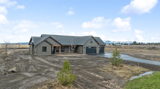 view of front facade featuring concrete driveway, an attached garage, and a shingled roof