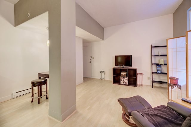 living area featuring wood finished floors, baseboards, and baseboard heating