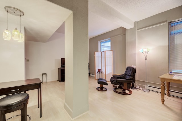 interior space with a textured ceiling, baseboards, and wood finished floors