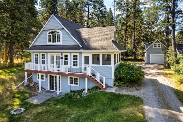 shingle-style home featuring french doors, roof with shingles, an outdoor structure, and a front yard