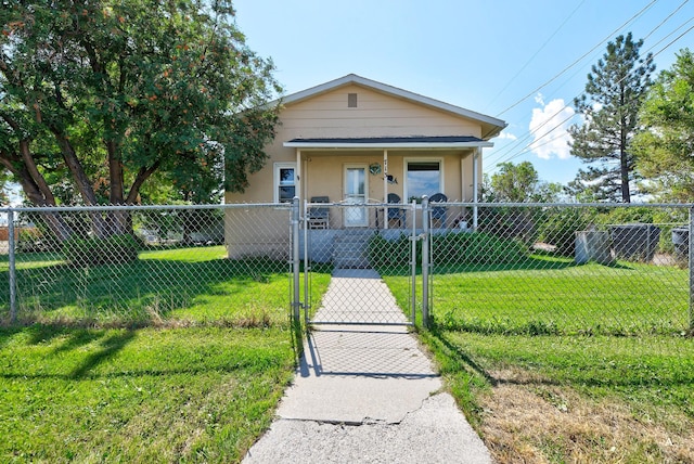 view of front facade with stucco siding, a front lawn, a gate, a fenced front yard, and covered porch