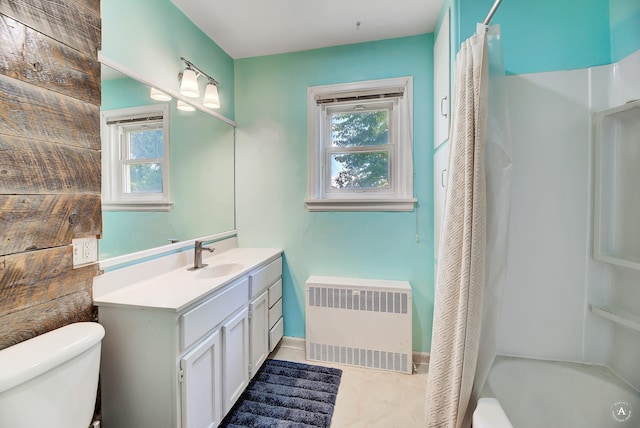 bathroom with toilet, radiator, vanity, and a wealth of natural light