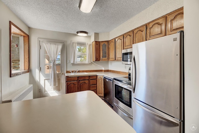 kitchen featuring baseboards, visible vents, a peninsula, a kitchen bar, and brown cabinets