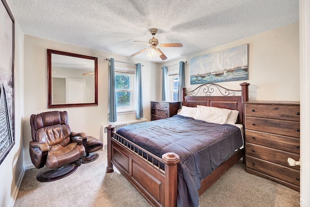 bedroom with a textured ceiling, a ceiling fan, and light carpet