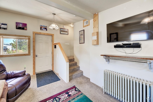 foyer with visible vents, carpet, beamed ceiling, stairway, and radiator heating unit