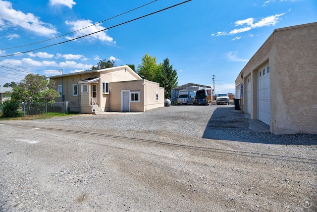 view of home's exterior featuring entry steps, fence, driveway, and stucco siding